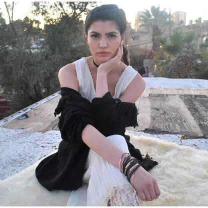 a woman sitting on a rock talking on a cell phone 