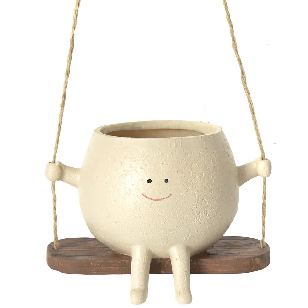 Smiling face planter on a rope swing with succulents, front view, white background